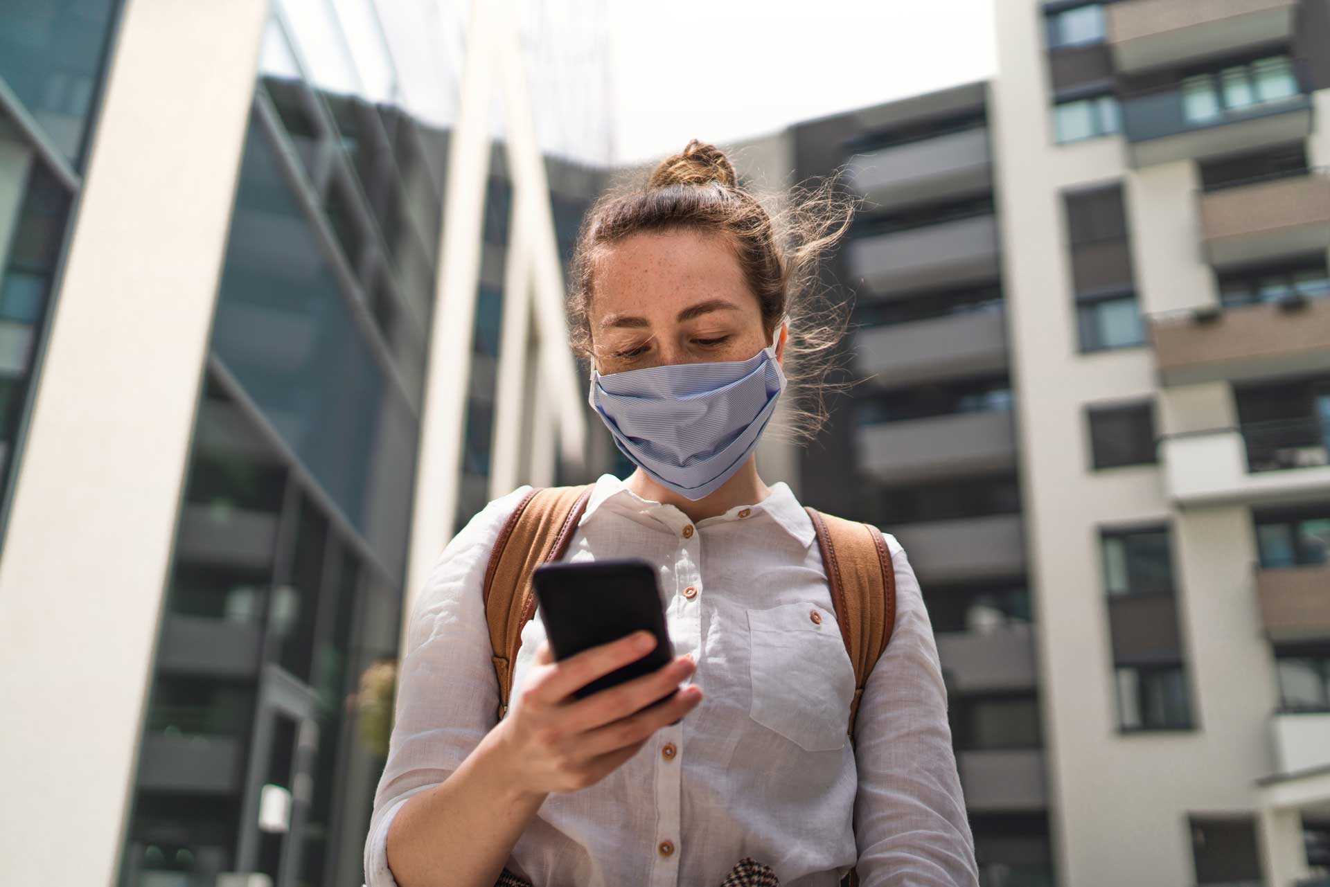 Girl wearing mask holding phone checking foundU app