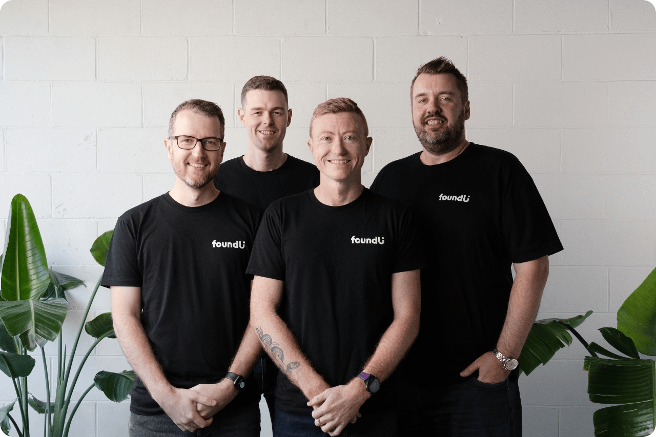 Group of men standing together wearing black foundU shirts